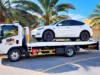 Electric car recovery Dubai: EV loaded on a flatbed tow truck