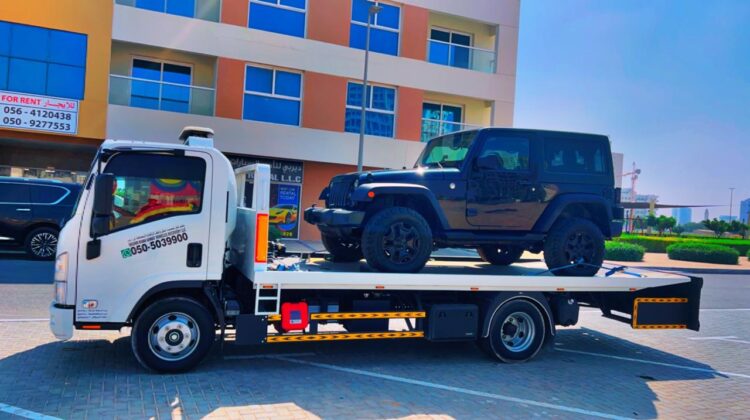 Car towing Dubai cost – flatbed tow truck loading an SUV